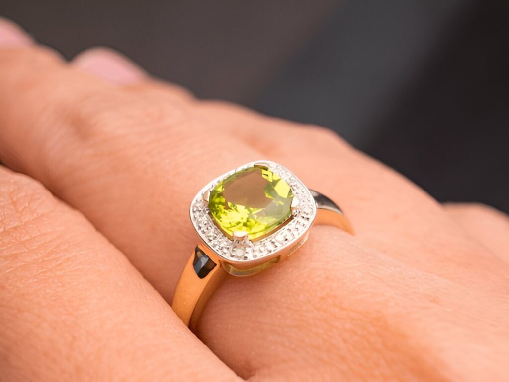 green peridot Jewel gemstone ring on woman hand put on black background