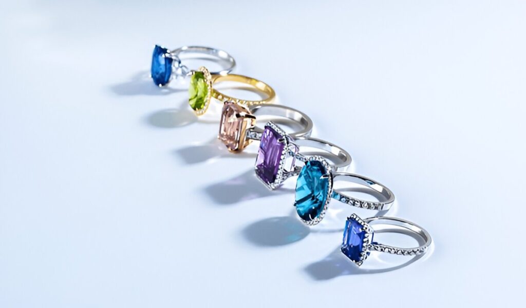 multi colored gemstone rings on white background.